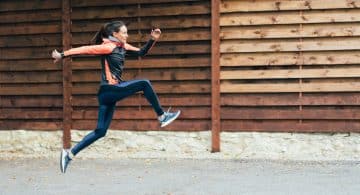 Donna esegue un salto durante la corsa all’aperto