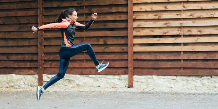 Donna esegue un salto durante la corsa all’aperto