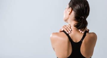 Donna vista di schiena che si massaggia il collo