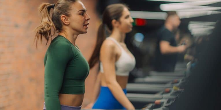 Persone che si allenano su tapis roulant in palestra
