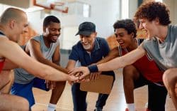 Allenatore e squadra di basket in palestra durante un momento di motivazione