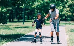 Adulto e bambino che pattinano insieme in un parco