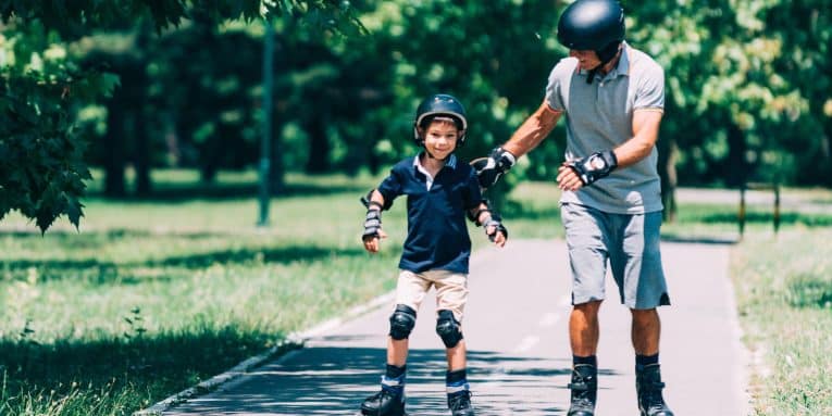 Adulto e bambino che pattinano insieme in un parco