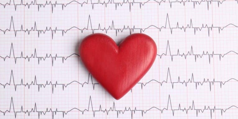 Cuore rosso appoggiato su un tracciato elettrocardiografico